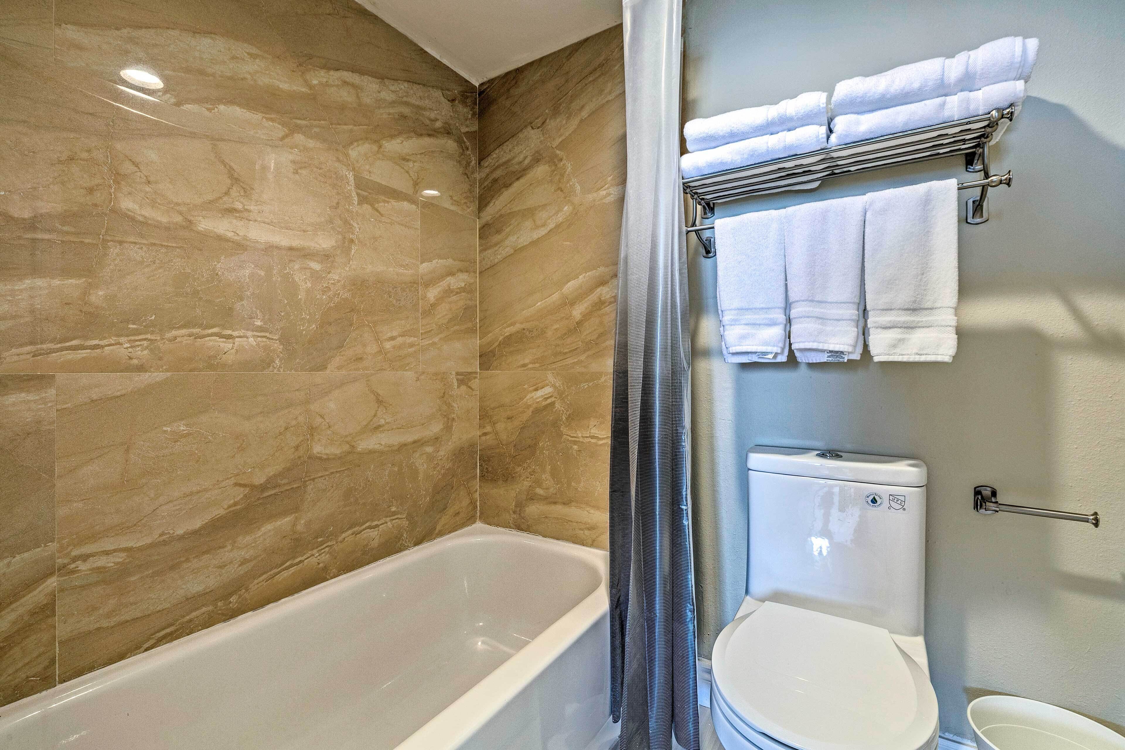 Une salle de bain avec une baignoire, des toilettes et un porte-serviettes.