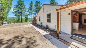 A single-story house with a covered porch, a small attached garage, and a well-maintained yard. - Ruidoso Cabin - Walk to Local Park + Downtown (Ruidoso)