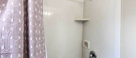 Ein Badezimmer mit Dusche, Toilette und Waschbecken.