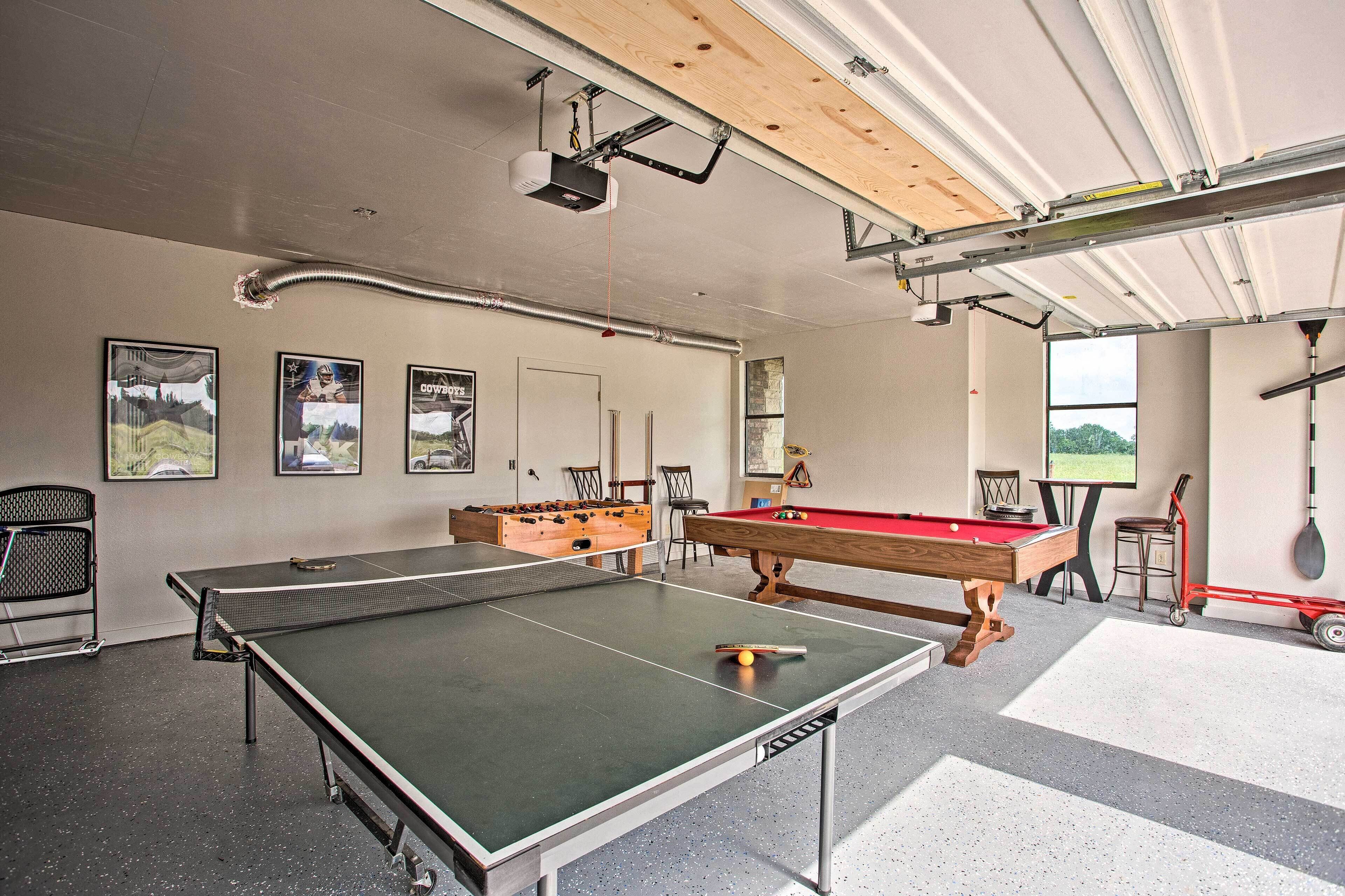 A recreational room with a ping pong table, pool table, and foosball table.