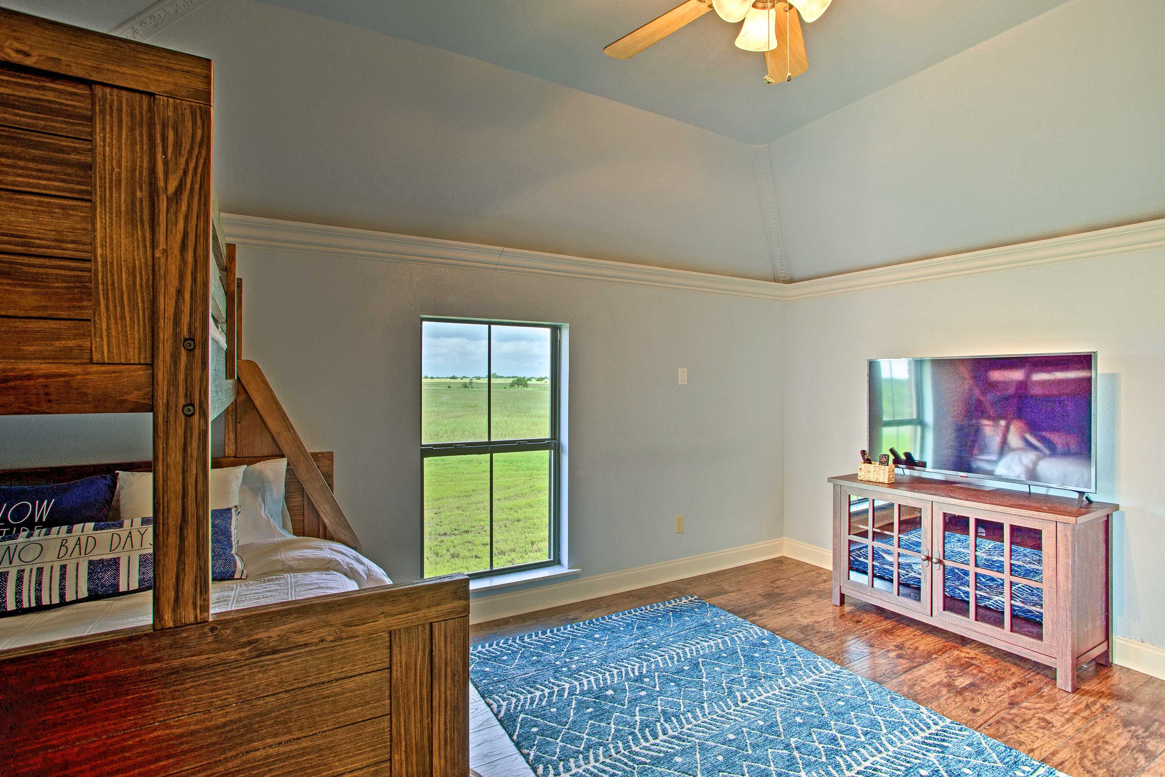 A room with a bed, a wooden cabinet, a television, and a large window.