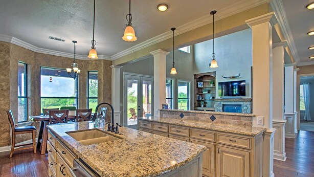 A spacious kitchen with granite countertops, wooden cabinets, and pendant lighting. - Home w/ Game Room & Fireplace: 14 Mi to Mckinney! (Blue Ridge)
