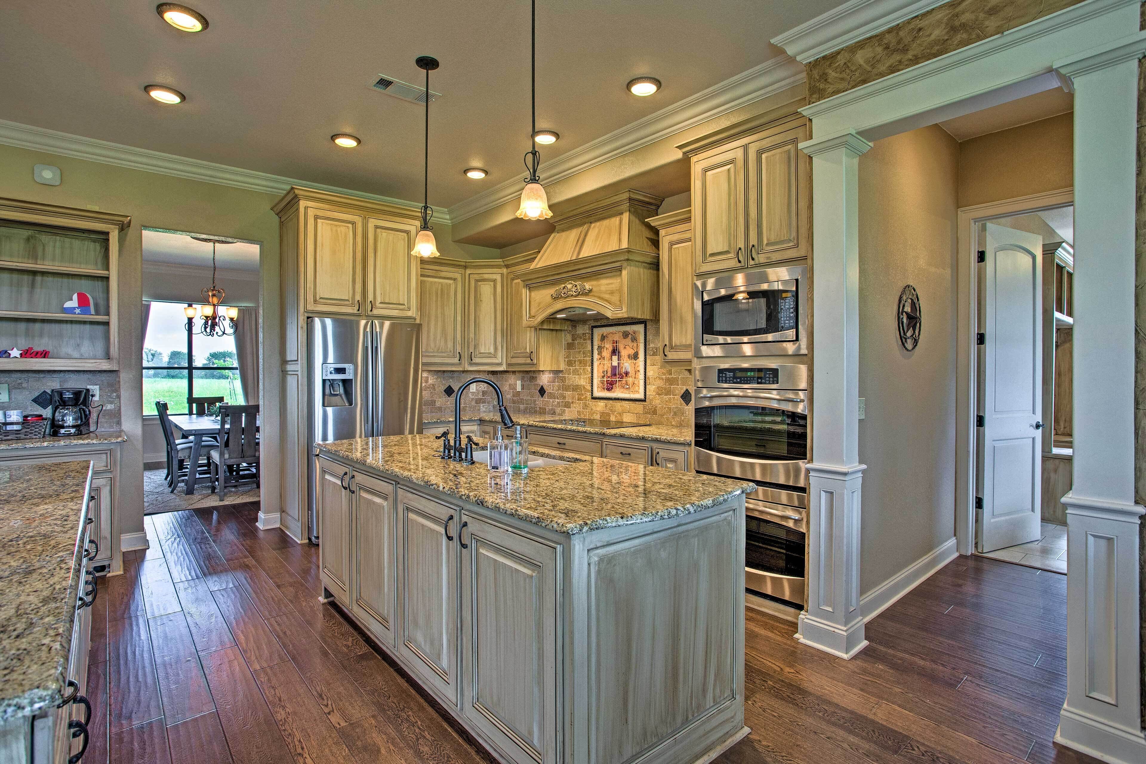 A spacious kitchen with granite countertops, stainless steel appliances, and a large island.