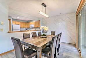 Una cocina moderna con armarios de madera, un refrigerador de acero inoxidable y un microondas integrado.