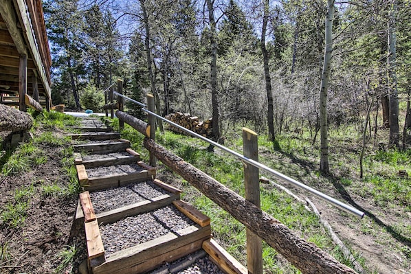 A wooden staircase leading up to a building surrounded by trees.