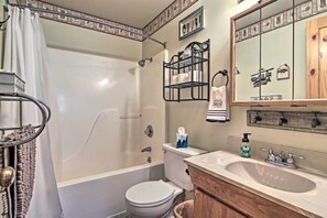 A bathroom with a bathtub, toilet, sink, and a mirror. - Florissant Hilltop Hideaway w/ Porch, Pond View (Florissant)