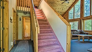 Ein Holzinnenraum mit einer Treppe, einer Couch und einem Deckenventilator.