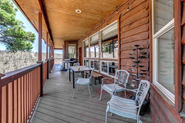 A wooden deck with outdoor seating, a table, and a decorative plant. - 19 Mi to Ski Apache! Cozy Ruidoso Digs Near Dtwn (Ruidoso)