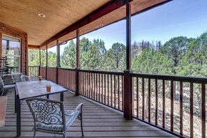 A covered outdoor area with a table and chairs, a railing, and a view of trees. - 19 Mi to Ski Apache! Cozy Ruidoso Digs Near Dtwn (Ruidoso)
