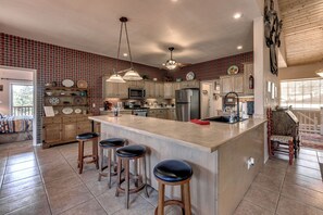 A spacious kitchen with a large island, bar stools, and a view of the living area. - 19 Mi to Ski Apache! Cozy Ruidoso Digs Near Dtwn (Ruidoso)