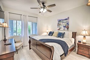 Relax in this serene bedroom with a large bed, ceiling fan, and comfortable seating area.