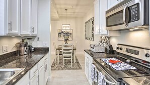 A modern kitchen with white cabinets, a stainless steel microwave, and a gas stove. - Bright Scottsdale Condo w/ Patio: 8 Mi to Old Town (Scottsdale)