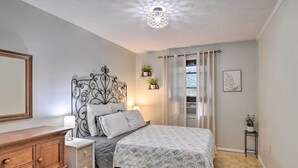 A bedroom with a bed, bedside table, dresser, and decorative wall art. - Enchanting Family House w/ Balcony < 3 Mi to Wvu! (Morgantown)