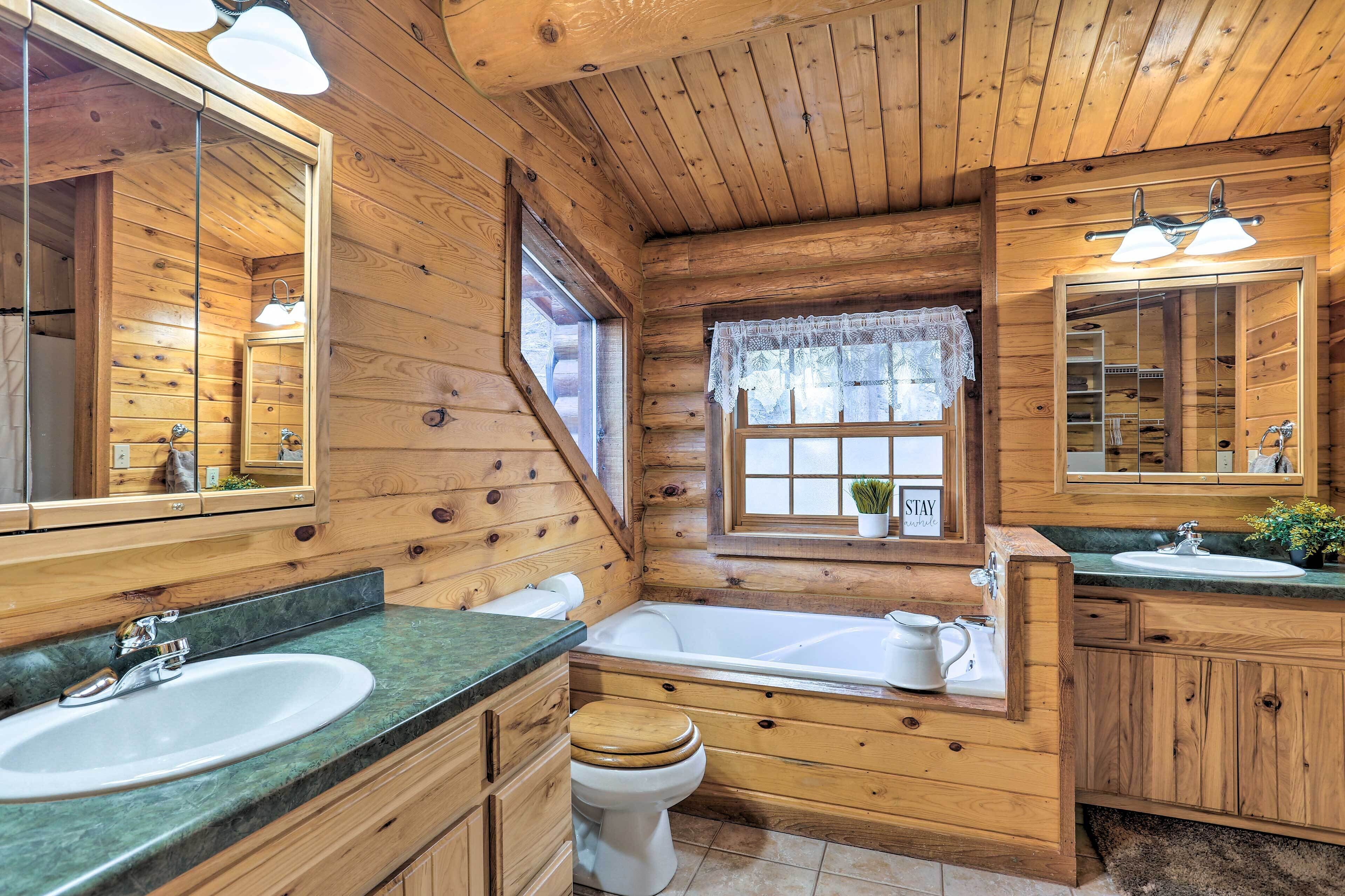 Ein Badezimmer im Holzblockhausstil mit Waschbecken, Toilette und Badewanne.