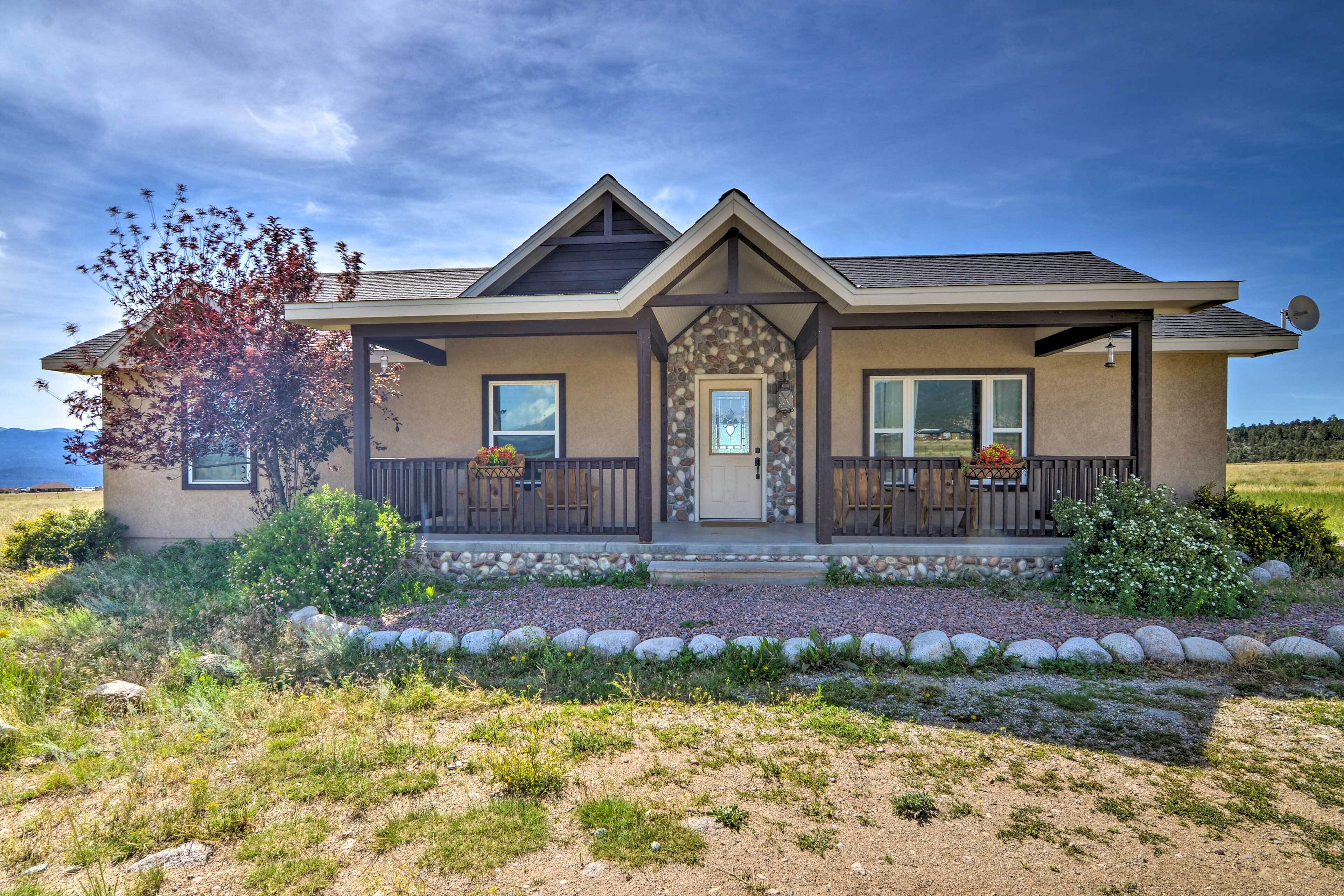 A modern two-story house with a stone facade, large windows, and a covered front porch.