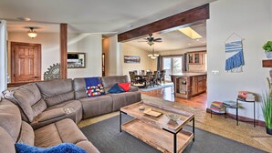 A spacious living room with a sectional sofa, a wooden coffee table, and a dining area with a chandelier. - 2 Mi to Hot Springs: Nathrop Gem w/ Fire Pit (Nathrop)