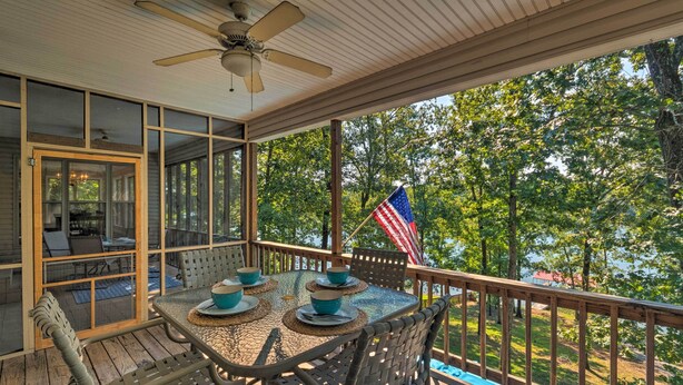 A covered outdoor patio with a table set for four, surrounded by wicker chairs, and an American flag. - Home on Lake Catherine w/ Dock 9 Mi to Hot Springs (Hot Springs)