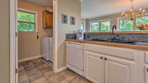 A kitchen with white cabinetry, a dishwasher, a granite countertop, and a chandelier. - Home on Lake Catherine w/ Dock 9 Mi to Hot Springs (Hot Springs)