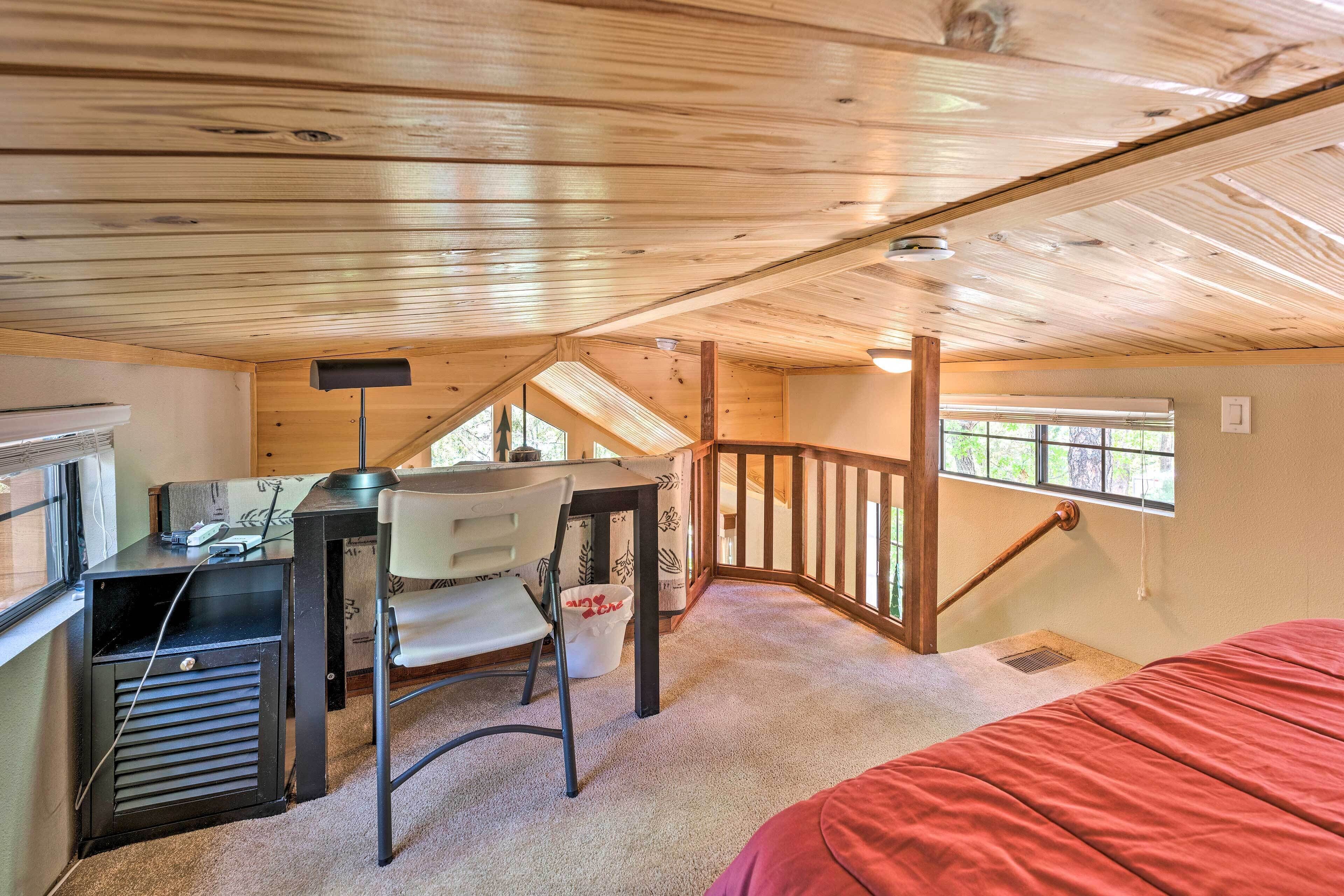 A bedroom with a desk, chair, and a bed.
