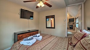 A bedroom with a bed, a dresser, a ceiling fan, a TV, and a mirror. - 6 Mi to Skiing: Family Poconos Home w Decks! (Albrightsville)