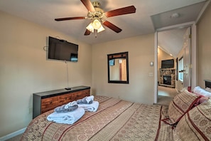 A bedroom with a bed, a dresser, a ceiling fan, a TV, and a mirror. - 6 Mi to Skiing: Family Poconos Home w Decks! (Albrightsville)