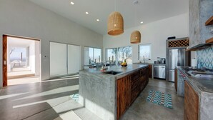 A spacious kitchen with a large island, modern appliances, and large windows offering views.