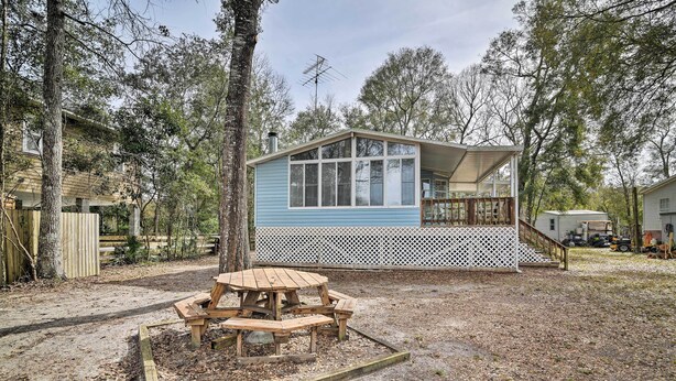 A small, single-story house with a blue exterior and white porch. - Fishing Paradise w/ Deck On Suwannee River (Branford)