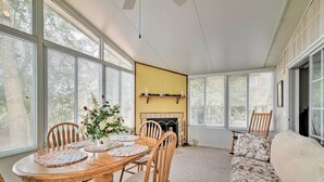 A dining area with a wooden table and chairs, a floral sofa, and large windows. - Fishing Paradise w/ Deck On Suwannee River (Branford)