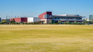 A modern building with a red and white facade, a large parking lot, and a clear blue sky. - 4 Mi to Mill Ave: Family Retreat w/ Patio in Tempe (Tempe)