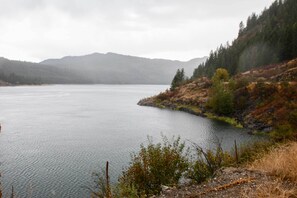 A calm lake surrounded by hills and sparse vegetation.