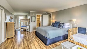 A bedroom with a large bed, a bedside table, a chair, a wardrobe, and a mirror. - Waterfront Home w/ Decks, Privacy & Boat Slip (Supply)