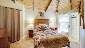 A bedroom with a wooden ceiling, a bed with a quilt, bedside lamps, a window, and a door. - 2 Decks, Mountain View: Beech Mountain Cabin! (Banner Elk)