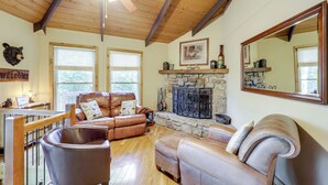 A cozy living room with leather sofas, a stone fireplace, and a large mirror. - 2 Decks, Mountain View: Beech Mountain Cabin! (Banner Elk)