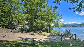 A lakeside picnic area with picnic tables, a small dock, and a boat. - Updated Bristol Lakehouse w/ Kayaks & Beach Access (Bristol)