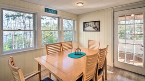 A dining area with a wooden table and chairs, a sign reading "LAKE", and a framed picture on the wall. - Updated Bristol Lakehouse w/ Kayaks & Beach Access (Bristol)