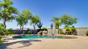 A swimming pool with a basketball hoop, surrounded by trees and a rocky landscape. - Luxe Scottsdale Home w/ Horse Stables & Pool! (Scottsdale)