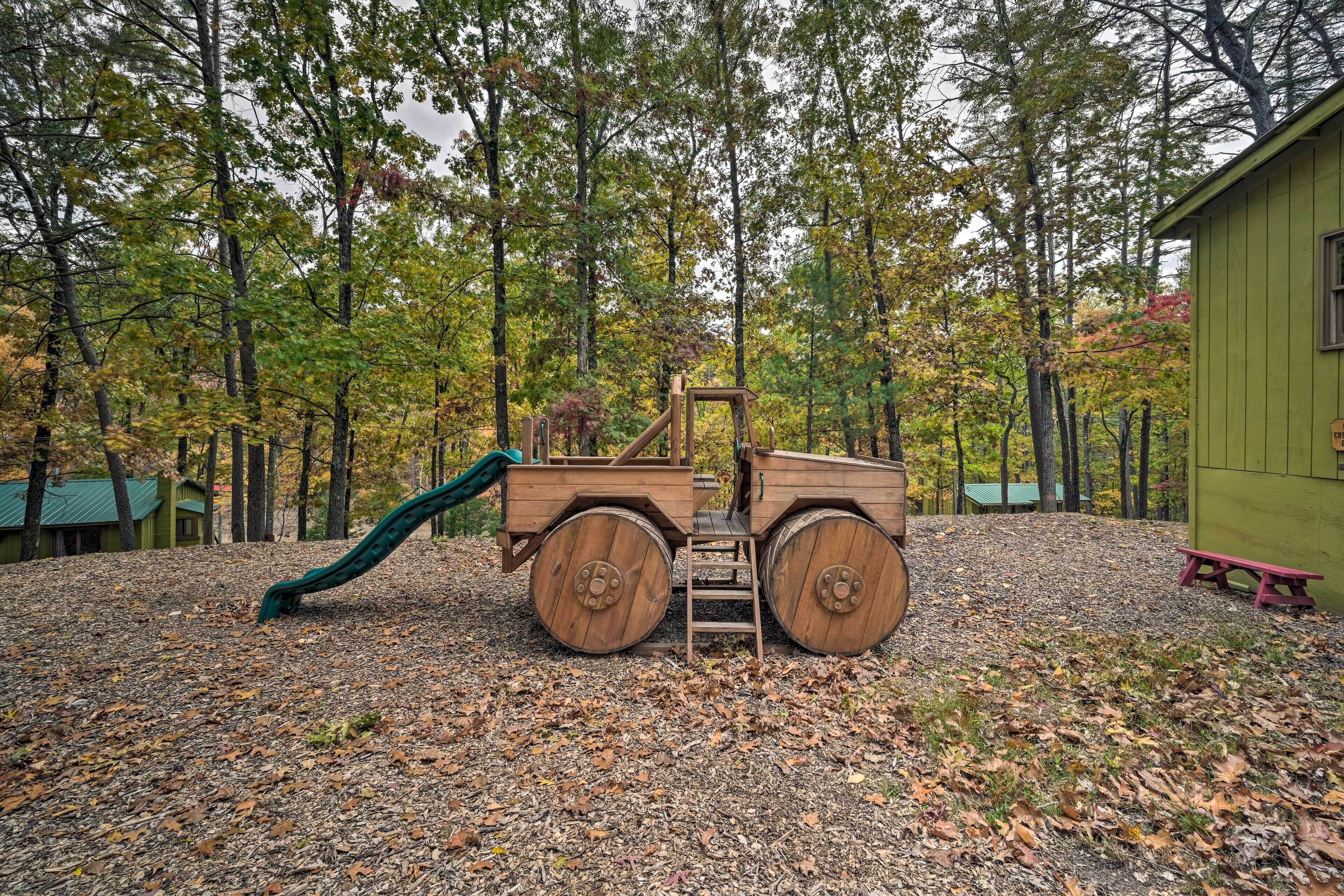 A playground with a wooden slide and a green play structure.