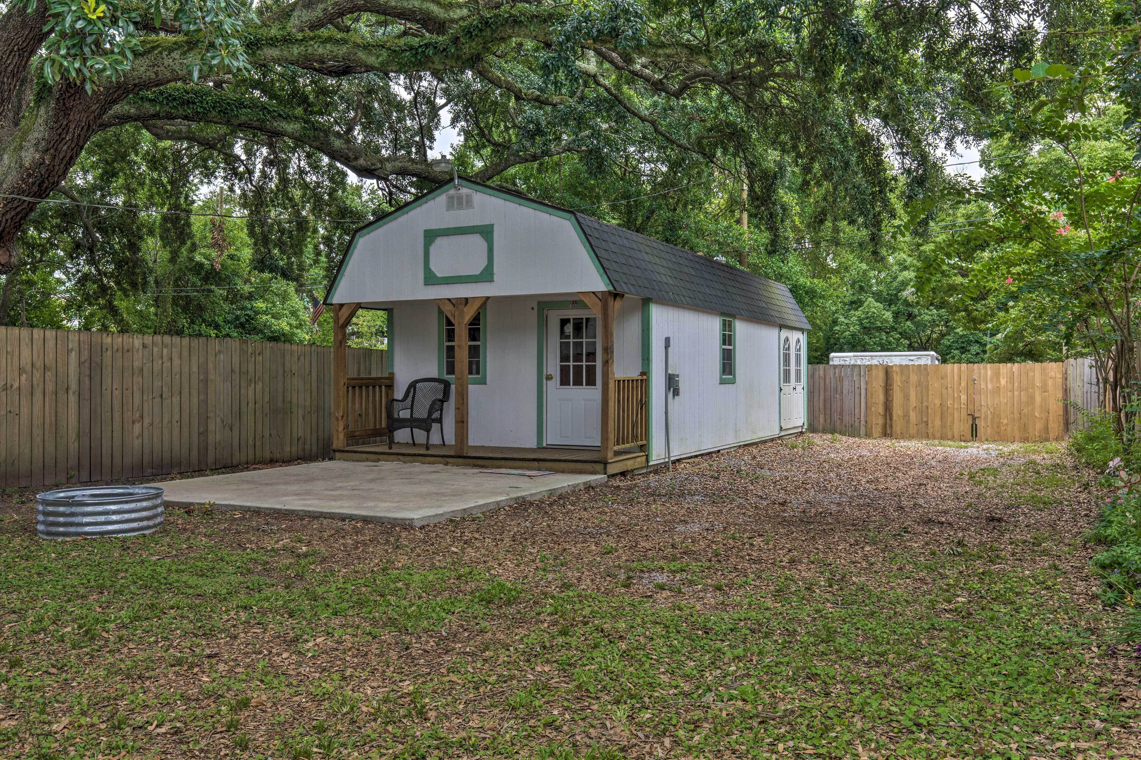 A small, single-story house with a porch and a covered patio area.