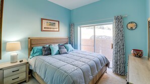 A bedroom with a bed, a nightstand, a lamp, a framed picture, a clock, and a window with curtains. - Desert Gem w/ Patio + Grill, Near Oracle St. Park! (Oracle)