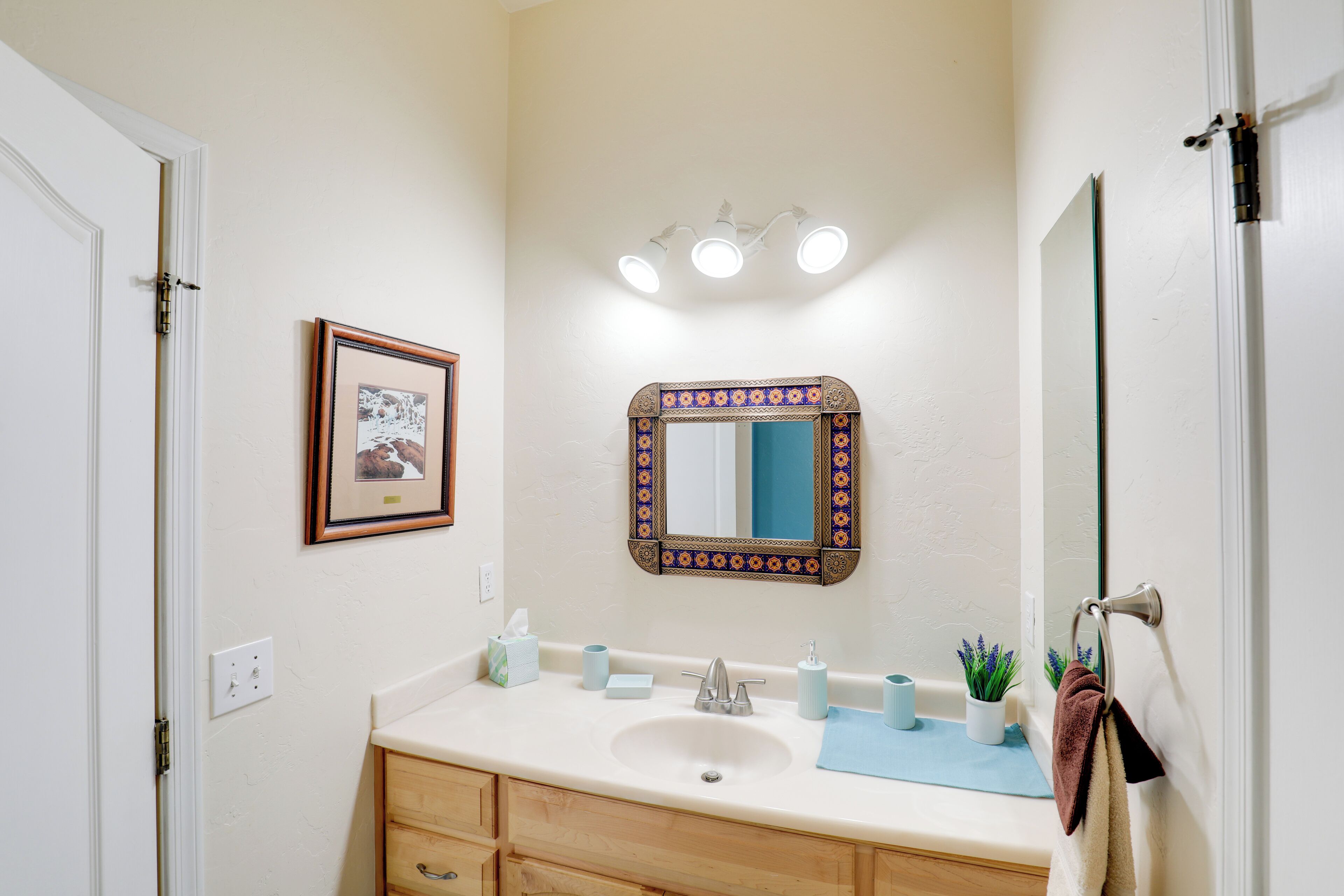A bathroom with a sink, mirror, and towel rack.