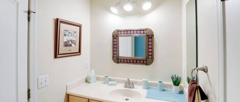 A bathroom with a sink, mirror, and towel rack.