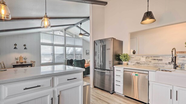 A modern kitchen with white cabinetry, stainless steel appliances, and pendant lighting. - Continental Country Club Gem w/ Covered Porch (Flagstaff)