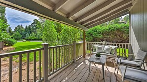 A covered porch with a view of a well-maintained lawn and trees. - Continental Country Club Gem w/ Covered Porch (Flagstaff)