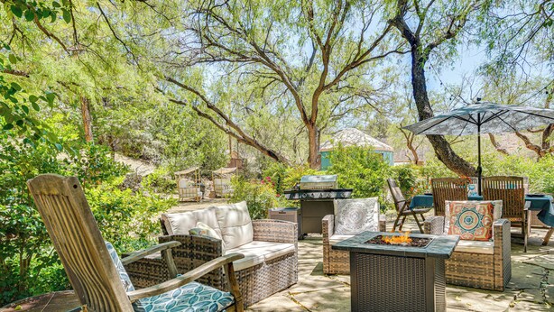 Un espace extérieur aménagé en terrasse, avec des meubles en osier, un foyer et un barbecue.