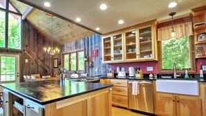 A kitchen with wooden cabinets, a large island, and a view of the outdoors. - East Burke House w/ Deck < 3 Mi to Kingdom Trails! (East Burke)