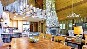 A rustic cabin interior with a dining area, kitchen, and living space. - East Burke House w/ Deck < 3 Mi to Kingdom Trails! (East Burke)