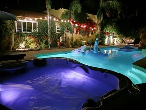 Ein Schwimmbeckenbereich mit Whirlpools und dekorativer Beleuchtung.