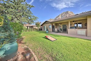 A residential property with a well-maintained lawn, a patio area, and a mountain backdrop.