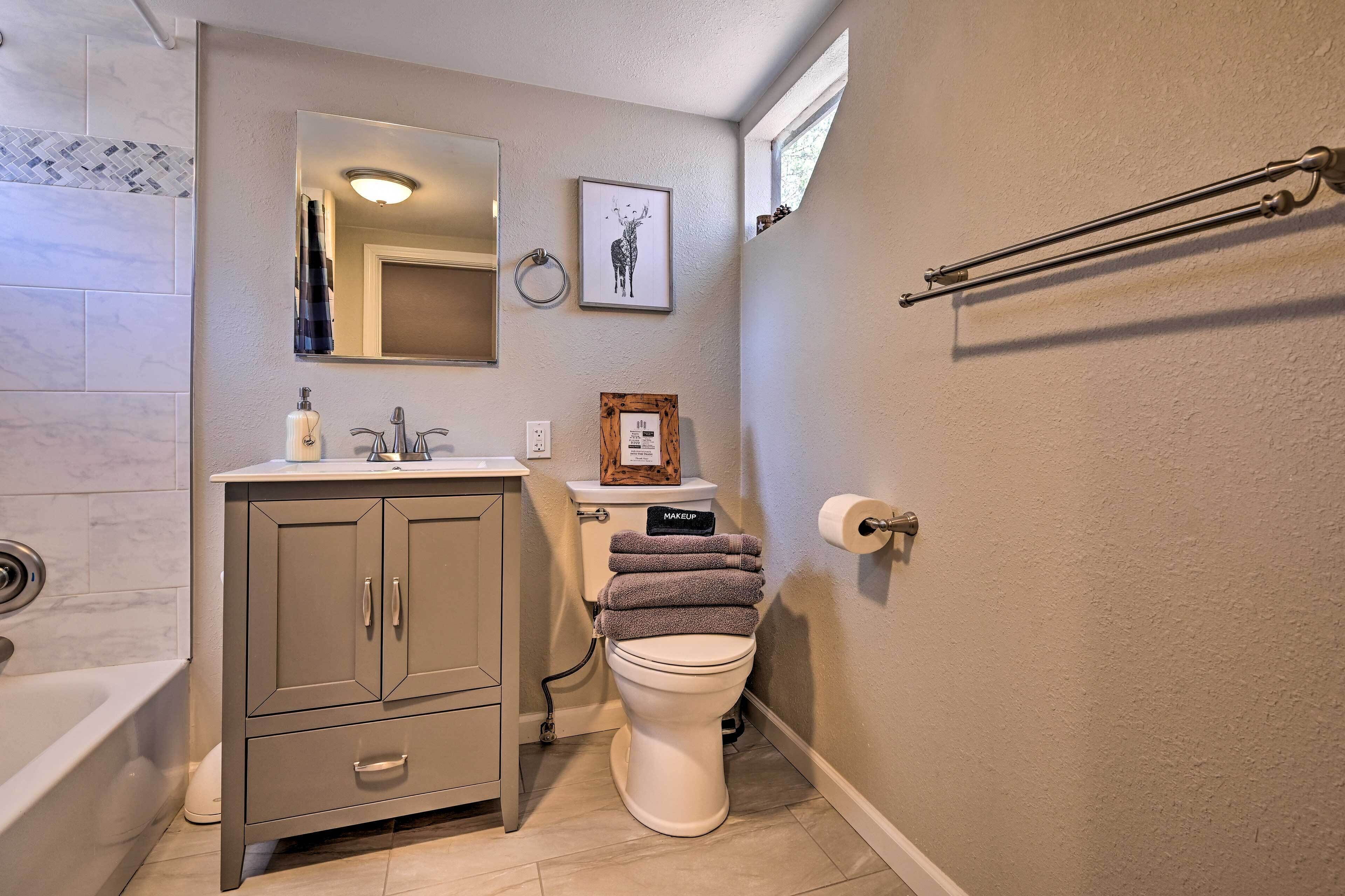 A bathroom with a toilet, sink, and bathtub.
