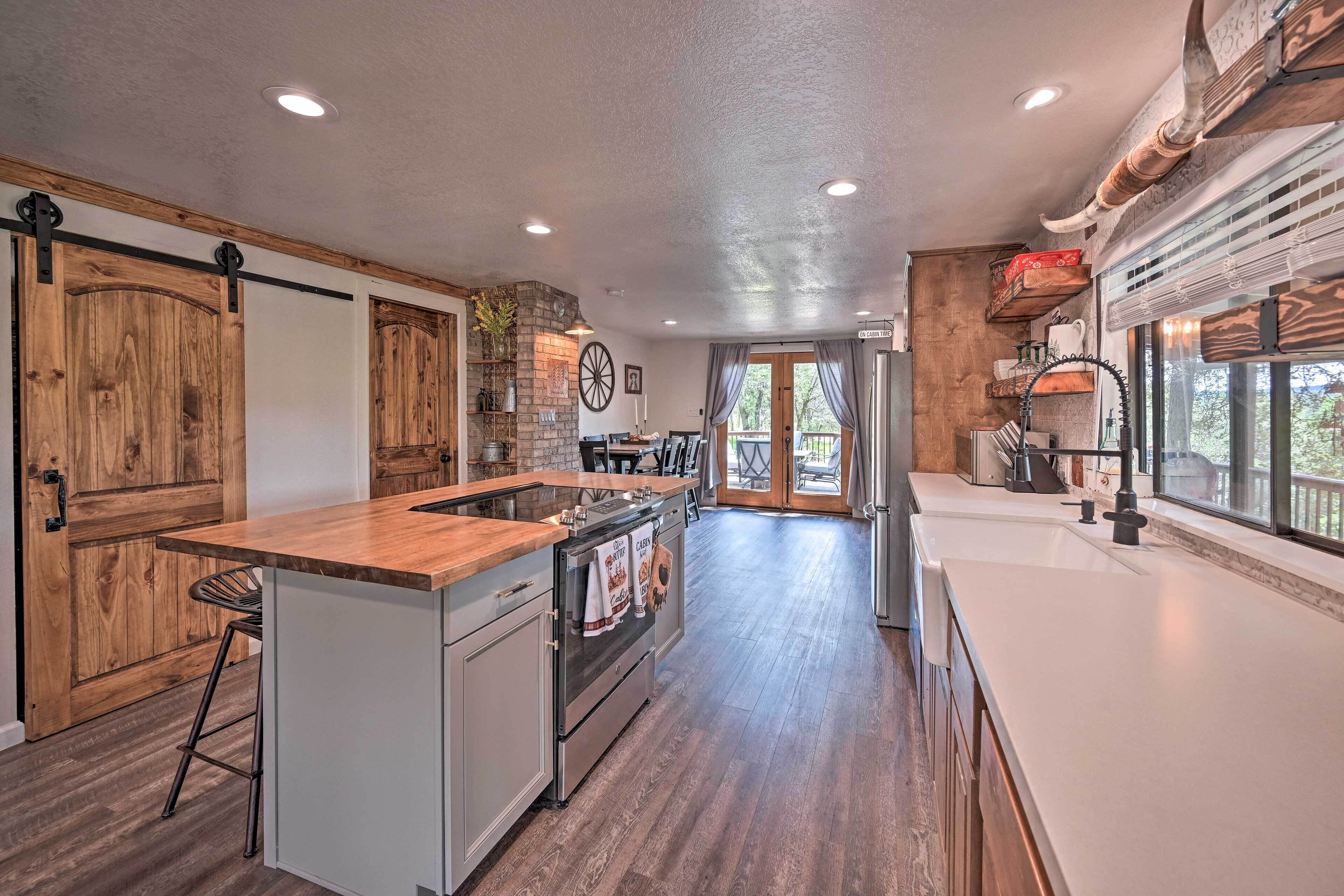 A spacious kitchen with a central island, wooden cabinets, and a large window providing natural light.